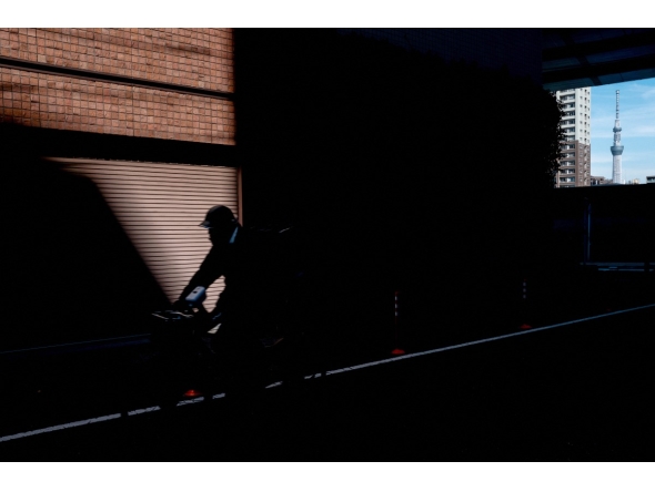 A person rides a bicycle as the Tokyo Skytree is seen in the background in Tokyo on February 10, 2026. (Photo by Philip FONG / AFP)