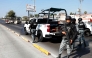 National Guard members stand guard near a burnt bus set on fire by organised crime groups in response to an operation in Jalisco to arrest a high-priority security target, at one of the main avenues in Zapopan, state of Jalisco, Mexico, on February 22, 2026. (Photo by Ulises RUIZ / AFP)