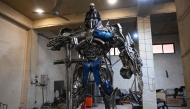 This photograph shows a worker weilding scrap metal into Optimus Prime, a film character from Transformers, at a studio on the outskirts of Islamabad. Sparks fly and metal groans in a cavernous workshop on the outskirts of Islamabad, where Pakistani artist Ehtisham Jadoon fuses discarded car parts into colossal pieces inspired by 