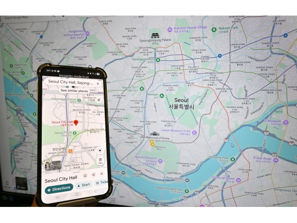 This photo illustration taken in Seoul on February 27, 2026 shows a Google Maps screen with a search for Seoul City Hall on a smartphone and a Google Maps webpage showing a map of Seoul. Photo by JUNG YEON-JE / AFP
