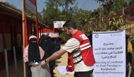 A Qatar Red Crescent Society representative distributing agricultural kits to female-headed households in Bangladesh.