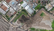 This aerial picture shows a rescue team using heavy machinery to search for people following a landslide at Bantargebang landfill in Bekasi, West Java, on March 9, 2026 (Photo by Bay Ismoyo / AFP)