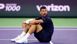 Novak Djokovic of Serbia sits up after falling to the court with exhaustion against Jack Draper of Great Britain in their fourth round match of the BNP Paribas Open at Indian Wells Tennis Garden on March 11, 2026, in Indian Wells, California.  (Photo by CLIVE BRUNSKILL / GETTY IMAGES NORTH AMERICA / Getty Images via AFP)