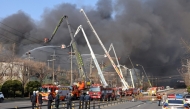 Firefighters spray water to extinguish a fire at a car parts plant in Daejeon on March 20, 2026. (Photo by Yonhap / AFP) 