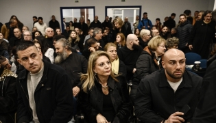Tempi 2023 Victims' Association president Maria Karystianou (C) sits with relatives inside the 