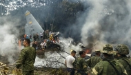 This screen grab shows soldiers and rescuers near an Air Force Hercules emitting thick smoke after the aircraft crashed during takeoff in Puerto Leguizamo, Colombia, near the southern border with Ecuador, on March 23, 2026. (Photo by daniel ortiz / AFP)
