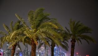 People walk along the Corniche area during a storm over Doha City in Qatar on March 26, 2026. (Photo by Mahmud HAMS / AFP)