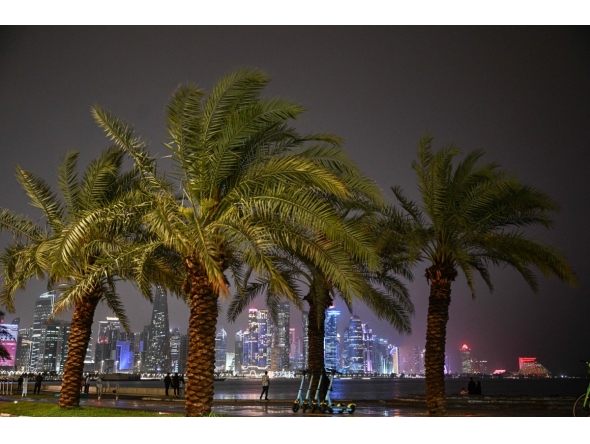 People walk along the Corniche area during a storm over Doha City in Qatar on March 26, 2026. (Photo by Mahmud HAMS / AFP)