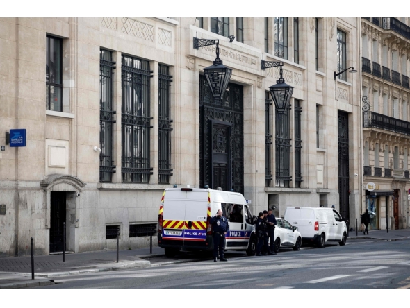 Police officials stand alongside police and private security vehicles outside The Bank of America building in the 8th arrondissement of Paris on March 28, 2026, following an apparent bomb attack attempt. (Photo by Sebastien Dupuy / AFP)