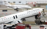 An executive jet taxis behind the Air Canada Express CRJ-900 that collided with a Port Authority fire truck at LaGuardia Airport in New York, after the airport resumed operations on March 23, 2026. Photo by TIMOTHY A. CLARY / AFP