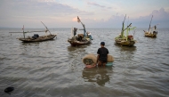 A man prepares to go fishing in Surabaya on March 30, 2026. (Photo by JUNI KRISWANTO / AFP)