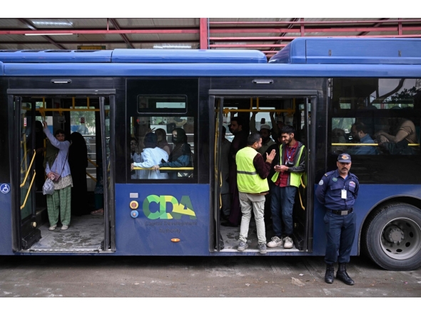 Passengers gather aboard a government bus at a bus stop in Islamabad on April 3, 2026. Photo by Farooq NAEEM / AFP