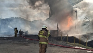 This handout picture released by the Panama Firefighting Department press office shows Panamanian firefighters tackling a blaze caused by the explosion of a fuel tanker under the Bridge of the Americas, at the Pacific entrance to the Panama Canal, in Panama City on April 6, 2026. (Photo by Handout / Panama Firefighting Department / AFP) 
