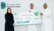 A Dukhan Bank official with the winner of the Thara'a campaign.