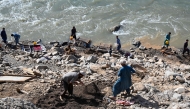 This photograph taken on April 13, 2026 shows Afghan men digging a mountainside along the Kunar riverbed before seiving stones in search of gold nuggets in the Song area of Ghaziabad district, Kunar province. (Photo by Wakil Kohsar / AFP)