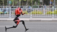 A robot runs in the second Beijing E-Town Half Marathon and humanoid Half Marathon in Beijing on April 19, 2026. Photo by Pedro PARDO / AFP