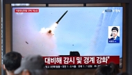 People watch a television screen showing a news broadcast with file footage of a North Korean missile test, at a train station in Seoul on April 19, 2026. Photo by Jung Yeon-je / AFP