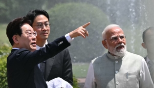 South Korea's President Lee Jae Myung (L) gestures alongside India's Prime Minister Narendra Modi (R) as they plant a tree during a meeting at the Hyderabad House in New Delhi on April 20, 2026. (Photo by Sajjad HUSSAIN / AFP)