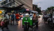 A tuk tuk drives past fruit stalls at Mahanak Market in Bangkok. (Photo by Anthony Wallace/ AFP)