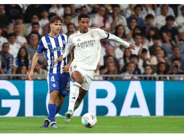 Real Madrid's English midfielder #05 Jude Bellingham fights for the ball with Alaves' Spanish midfielder #04 Denis Suarez during the Spanish league football match between Real Madrid CF and Deportivo Alaves at the Santiago Bernabeu stadium in Madrid on April 21, 2026. (Photo by Pierre-Philippe MARCOU / AFP)