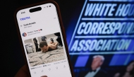 This illustration photo taken in Los Angeles shows a phone with a Truth Social post by US President Donald Trump displaying an image of the alleged suspect in a shooting incident at the White House Correspondents’ Dinner on the ground after being apprehended on April 25, 2026. (Photo by Chris Delmas / AFP)