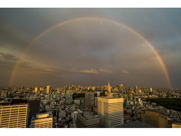 A general view shows the city skyline and a rainbow from the Tokyo Metropolitan Government Building observation deck in the Shinjuku district of central Tokyo on April 27, 2026. (Photo by Philip FONG / AFP)