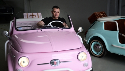 Owner of the Officine Gentile garage, Giovanni Gentile sits at the wheel of a model of a Fiat 500 Jolly Lido at his workshop in Turin on April 30, 2026. (Photo by Marco Bertorello / AFP)
