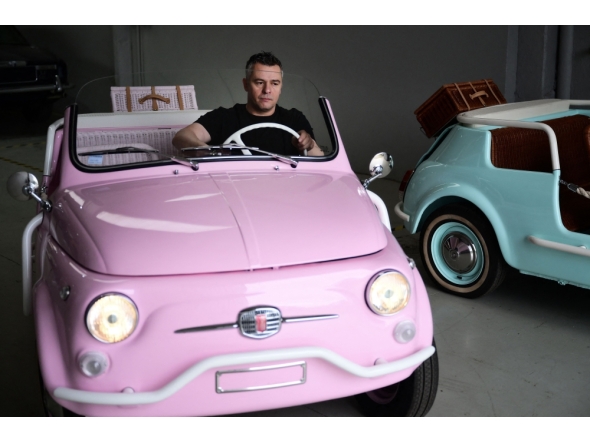 Owner of the Officine Gentile garage, Giovanni Gentile sits at the wheel of a model of a Fiat 500 Jolly Lido at his workshop in Turin on April 30, 2026. (Photo by Marco Bertorello / AFP)