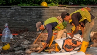 A road construction crew works at dusk in Jakarta on May 6, 2026. (Photo by BAY ISMOYO / AFP)