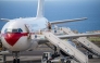 A Spanish evacuee wearing a white hazmat protective suit boards the rear door of a Spanish air force Airbus A310 plane at the Tenerife Sur-Reina Sofia airport after being evacuated from the Dutch flagged hantavirus-stricken cruise ship MV Hondius which anchored at the industrial port of Granadilla de Abona on the island of Tenerife in Spain's Canary Islands on May 10, 2026. Photo by Antonio Sempere / AFP