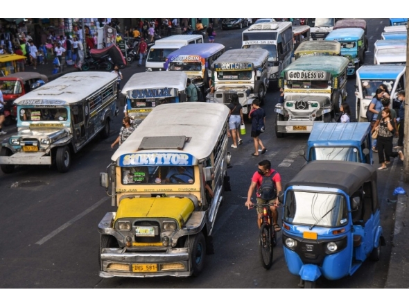 In this photo taken on April 5, 2024, jeepneys commute along a street in Manila. (Photo by Ted ALJIBE / AFP)