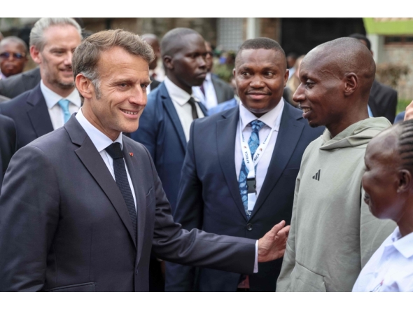 France's President Emmanuel Macron (L) speaks with Kenya's Sabastian Sawe (2nd R), the first man to run under two hours for a marathon in race conditions at a sport demonstration during the Africa Forward summit in Nairobi on May 11, 2026. (Photo by Ludovic Marin / AFP)

