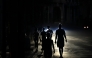 People walk on a street during a blackout in Havana, Cuba. (Photo by Yamil Lage / AFP)