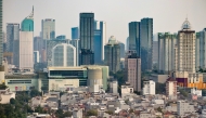 Commercial high-rises buildings are pictured behind low-rise buildings in Jakarta on May 7, 2026. (Photo by BAY ISMOYO / AFP)
