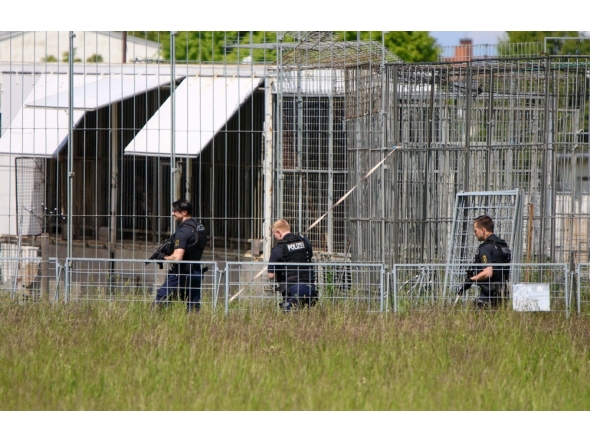 A picture showing heavily armed police officers in an industrial area at a cage facility in Schkeuditz near Leipzig, Saxony, eastern Germany, after an escaped tiger injured a man and was shot dead.  (Photo by Bjِrn Stach / dpa / AFP) / Germany OUT
 