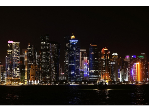 Illuminated skyscrapers are pictured along the corniche promenade in Doha on May 15, 2026. (Photo by Karim JAAFAR / AFP)
