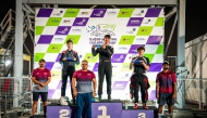 The podium winners of the third round pose with officials. 