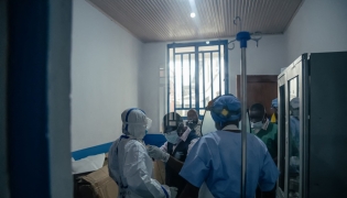 Dr Abdou Sebushishe (2nd L) Senior Health Advisor at International Medical Corps, guides and shows CBCA Virunga doctors how to properly put on single-use personal protective equipment provided by International Medical Corps, as part of support for Ebola virus disease prevention measures in Goma, on May 21, 2026. (Photo by Jospin Mwisha / AFP)