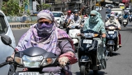 Commuters with their faces covered with cloth ride along a street on a hot summer afternoon in Amritsar on May 23, 2026. (Photo by Narinder NANU / AFP)
 