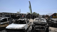 A crane lifts a carriage of a train at the site after an explosion that targeted a train in Quetta on May 24, 2026. (Photo by Banaras Khan / AFP)