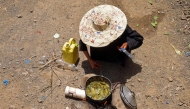 Displaced Yemeni woman Saeedah Mohammed boils tree leaves to feed her grand-children outside their makeshift tent in the Al-Manij displacement camp, near the city of Taez in Yemen's southwest, on May 21, 2026. (Photo by Ahmed al-Basha / AFP)