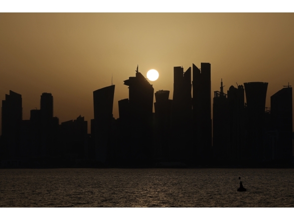 Skyscraper buildings are silhouetted against the setting sun in Doha on May 24, 2026. (Photo by Karim Jaafar / AFP)