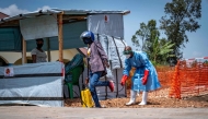 Dieudonné Sezabo, a health worker, decontaminates the clothing of a motorcycle taxi driver who transported a patient suspected of having Ebola to the Rwampara Hospital in Ituri, in the eastern Democratic Republic of the Congo. (Photo by Glody Murhabazi / AFP)