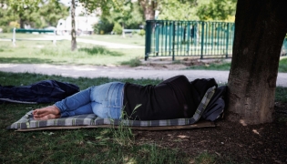 A person lies on a mattress under a tree in a park, in Paris on May 29, 2026 as a heatwave hits France.  (Photo by Simon Wohlfahrt / AFP)