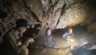 This screengrab made from handout video footage taken on May 29, 2026, shows a rescue team (C, R) about to free one (L) of seven men trapped in a semi-submerged cave. (Photo by Handout / Benz Norrased Palasing / Seascout Diving / AFP) 