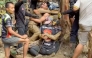 This screen grab made from handout video footage taken on May 30, 2026, and provided by Adisak Wongsoraya, shows two men (centre L and centre R, with headlamp) being hugged after they were rescued from a semi-submerged cave in Laos' central Xaysomboun province, northeast of the capital Vientiane. Photo by Handout / Adisak Wongsoraya / AFP