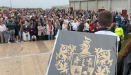 The O’Sullivan clan family crest is held by a participant in a bid to break a world record for the largest gathering of people with the same surname, in Castletownbere, Ireland (Photo by Peter Murphy/ AFP)