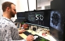 In this photo taken on May 5, 2026, chief scientific and operations officer Brett Kagan looks at cortical and hippocampal cells on cell culture plates in Melbourne. (Photo by William West / AFP) 