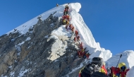 (Files) This photograph taken on May 20, 2026, shows mountaineers climbing a slope lined up during their ascent from the Hillary Step to summit Mount Everest in Nepal. (Photo by Furte Sherpa / AFP)