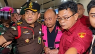 Dadan Hindayana (C), former head of Indonesia's free school meals programme, is escorted by officers from the Attorney General's Office and Indonesian military personnel as he leaves the Attorney General's Office building in Jakarta on June 3, 2026, following questioning over alleged misappropriation in the implementation of the programme. Photo by Diyah Nasution / AFP